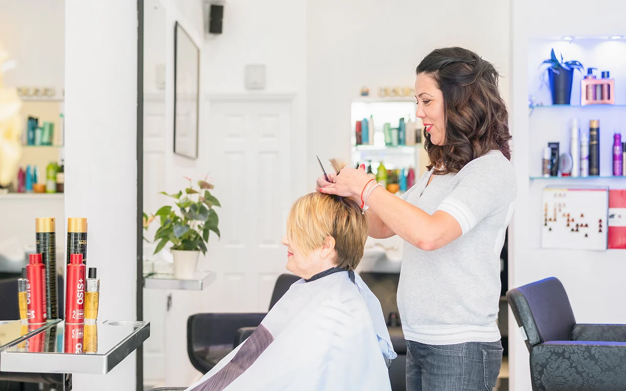 Alfiya cutting a client's hair at her Finchley Central salon chair